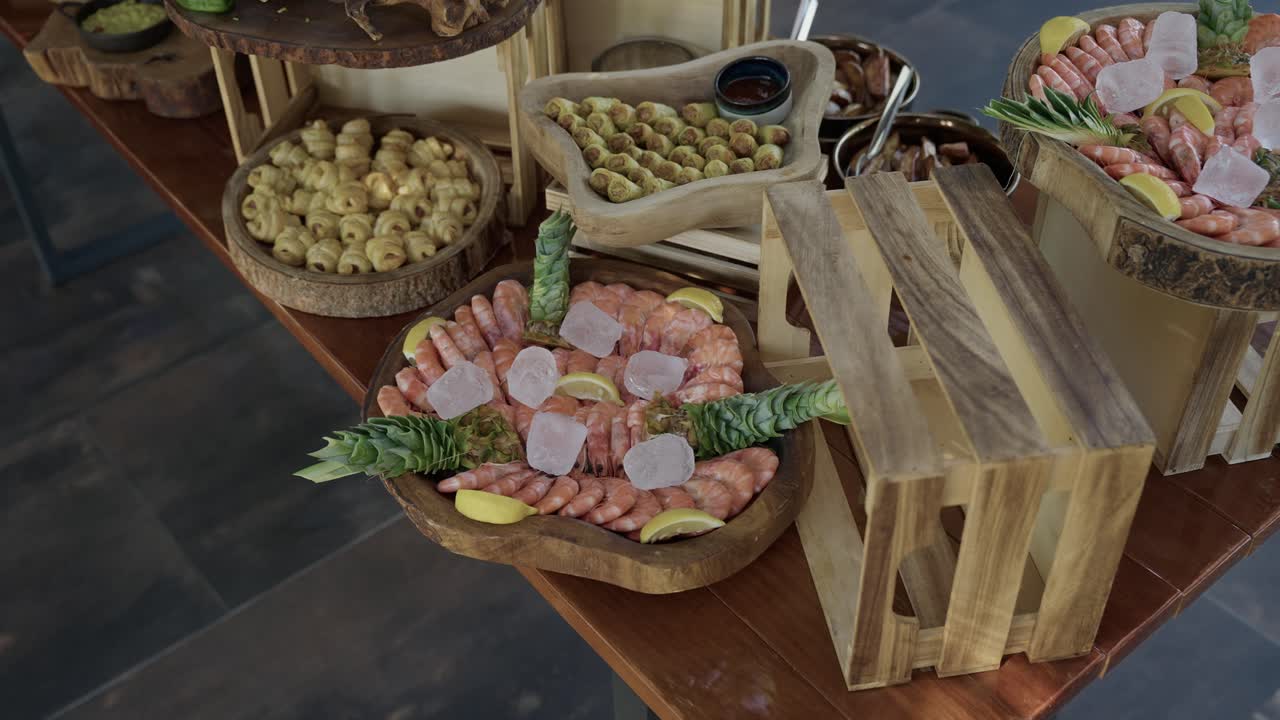 Piatto di gamberi con fette di limone e ghiaccio su un tavolo da buffet con olive.