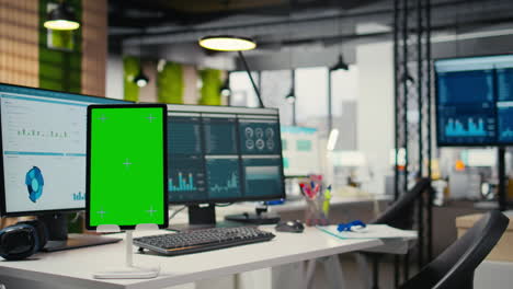 vertical video modern empty office displays green screen on tablet at workstation