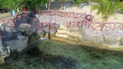 aerial drone shot of a tourist relaxing at a shoreline resort in philippines