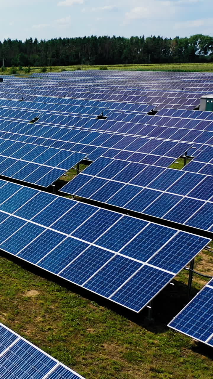 Aerial solar photovoltaic. Aerial view of solar energy modules along land Vertical video