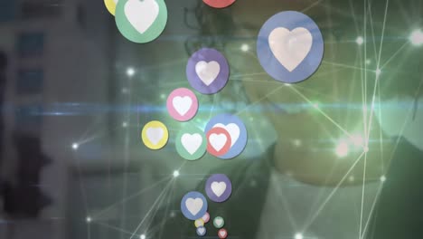Animation-of-heart-icons-and-glowing-network-of-connections-over-biracial-man-using-a-smartphone