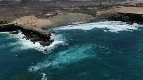 la pared beach, fuerteventura: aerial view traveling out over the beach and the rock formation that is there, on the island of fuerteventura on a sunny day