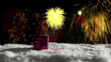 Animation-of-christmas-present-in-snow-and-yellow-fireworks-exploding-in-night-sky