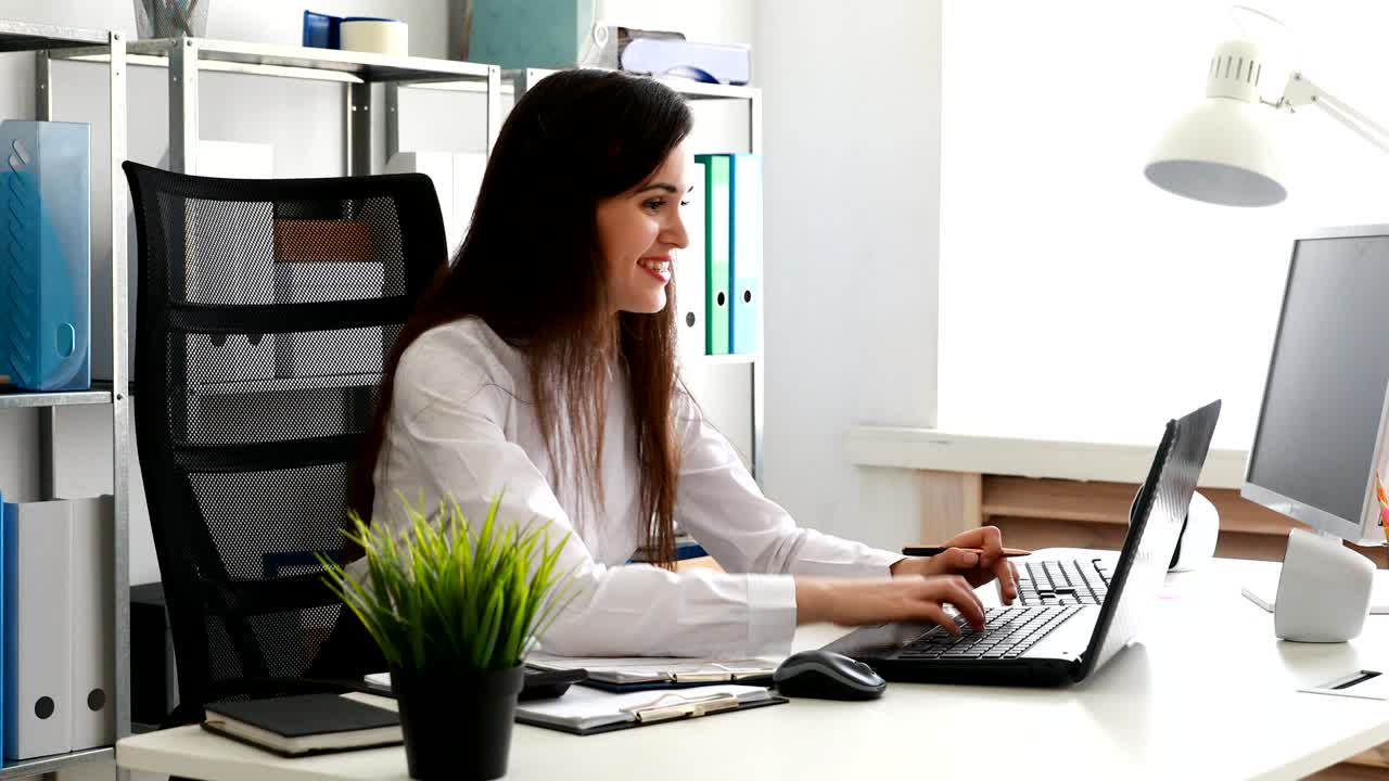 mujer de negocios mirando documentos y trabajando en una computadora portátil en una oficina moderna