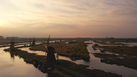 drone shot slowly rotating to the left at the windmills of kinderdijk at sunset in 4k