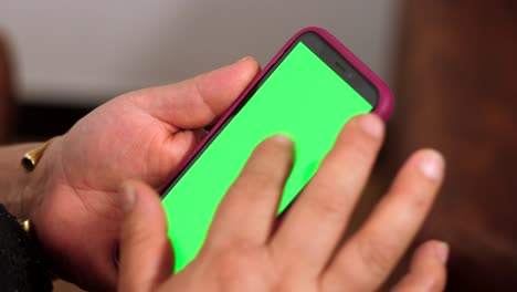 adult woman hands manipulating cell phone with green screen, chroma