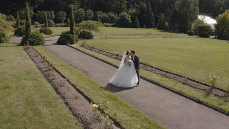 Newlyweds,-Caucasian-groom-with-bride-making-a-kiss-in-park,-Wedding-couple,-Man-and-woman-in-love