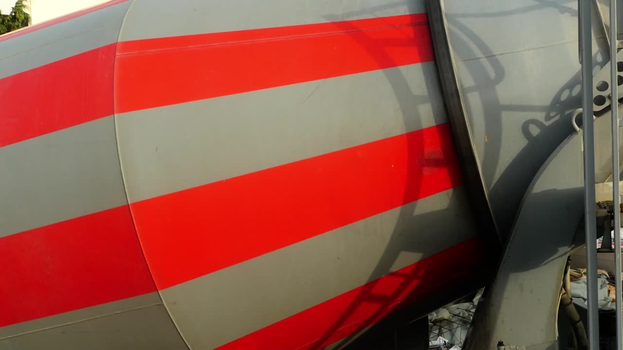 회색과 빨간색 콘크리트 믹서가 아침 햇살에 변한다