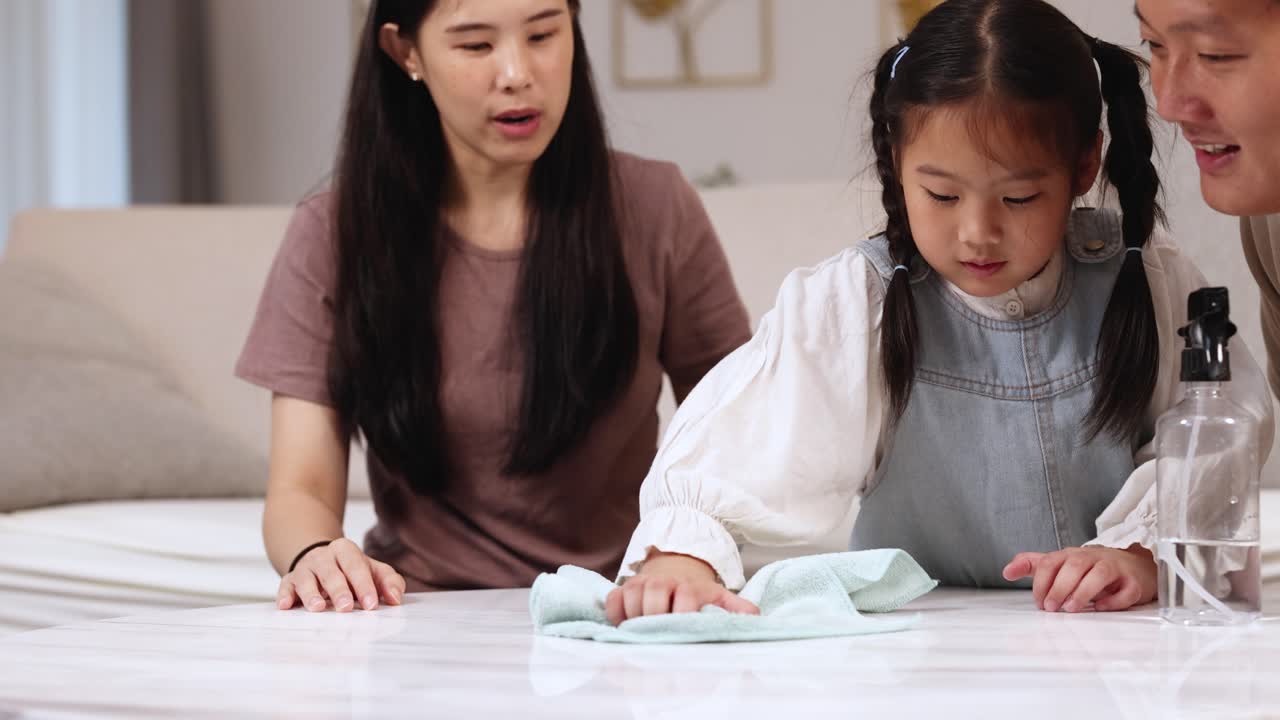 A family cleans a desk together, fostering teamwork and connection in a warm, well-lit home environment