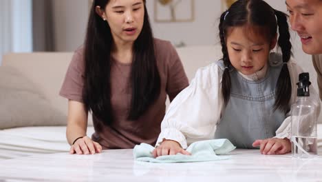 a family cleans a desk together, fostering teamwork and connection in a warm, well-lit home environment