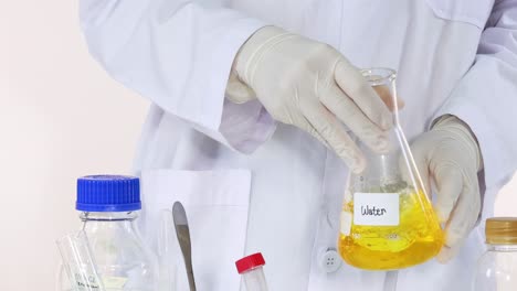 científico que agita una sustancia amarilla en un entorno de laboratorio
