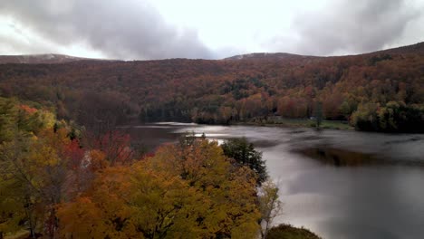 aerial over cabin by the lake in fall in vermont