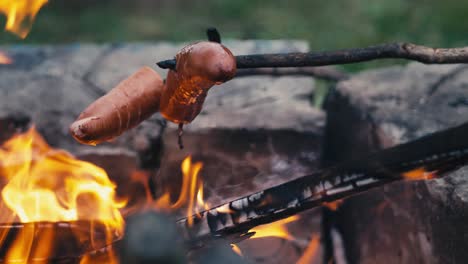 Braten-Von-Würstchen-Am-Spieß-Auf-Einem-Lagerfeuer-Nach-Einbruch-Der-Dunkelheit