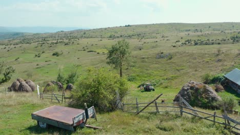 Toma-Aérea-Dando-Vueltas-De-Cerca-Alrededor-De-Una-Granja-Rústica-Aislada-En-Un-Día-Brillante