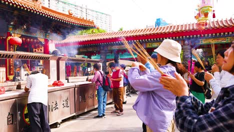 people praying with incense at hong kong temple