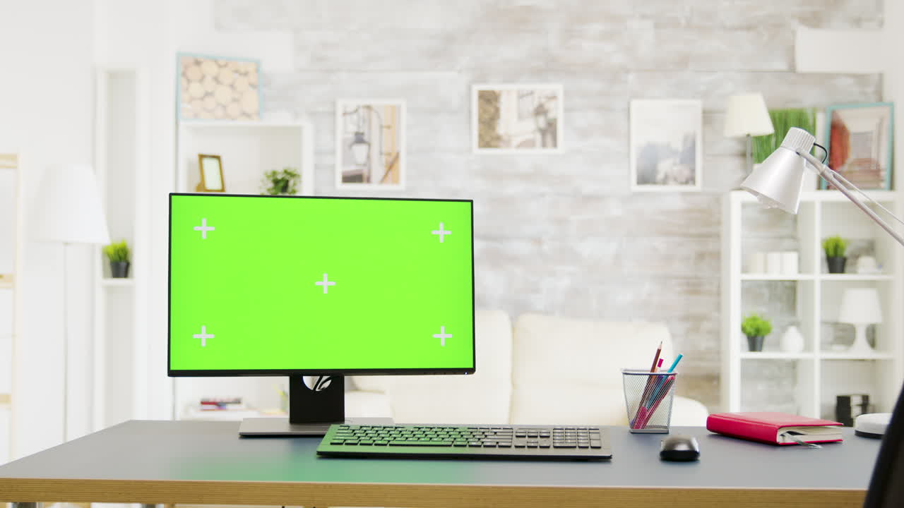 책상 위에 초록색 화면이 있는 컴퓨터
