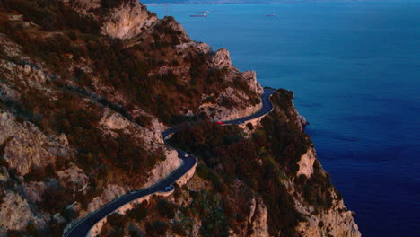 long winding road around sunset red amalfi coast, southern italy overlooking tyrrhenian sea, aerial view