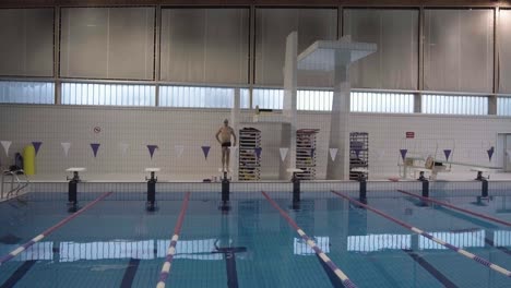 AERIAL SHOT OF A MAN DIVING IN A POOL
