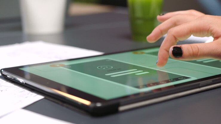 Person med en tablet, der viser en mobilapp-prototype