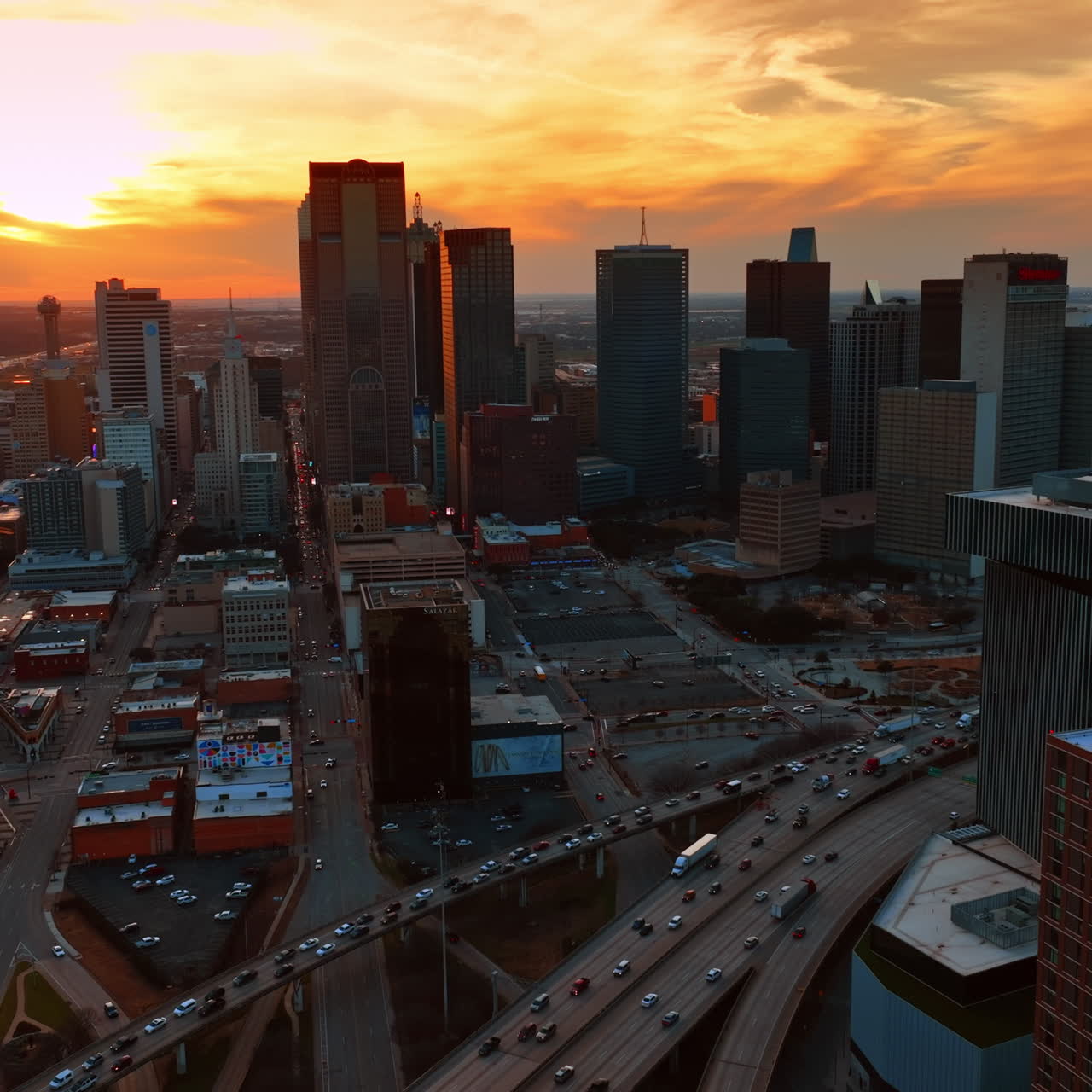 Céu alaranjado deslumbrante sobre o panorama de Dallas, Texas, EUA. Tráfego intenso no centro da cidade, em vista aérea.