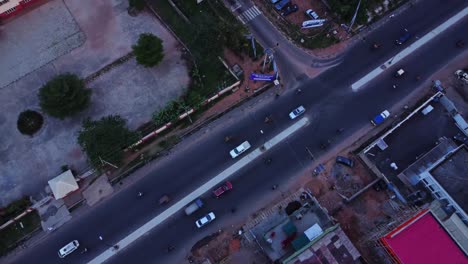 top down aerial of traffic commuting over a busy road in ibadan, nigeria. the camera slowly spins while cars driver over the street