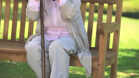 Elderly-woman-thinking-while-holding-her-walking-stick