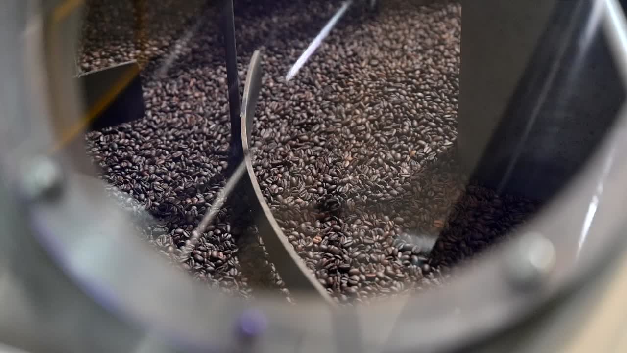 Proses sangrai kopi dan produksi biji kopi coklat dicampur dan didinginkan setelah disangrai dalam wadah.