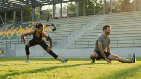 Joven-Pareja-De-Corredores-Entrenando-En-El-Estadio-En-Un-Día-Soleado