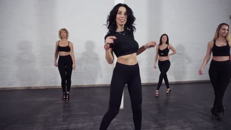 imágenes en cámara lenta de un grupo de mujeres atractivas y sexys bailando bachata, aprendiendo movimientos geniales.