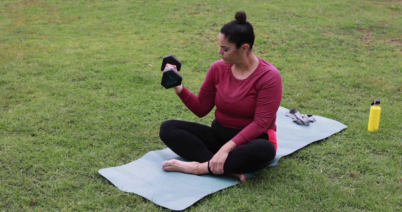 Woman Exercising with Dumbbell on Yoga Mat in Park