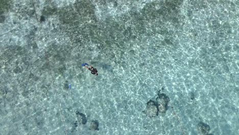 Man-snorkeling-in-crystal-clear-water-during-sunny-day-on-Gili-Air