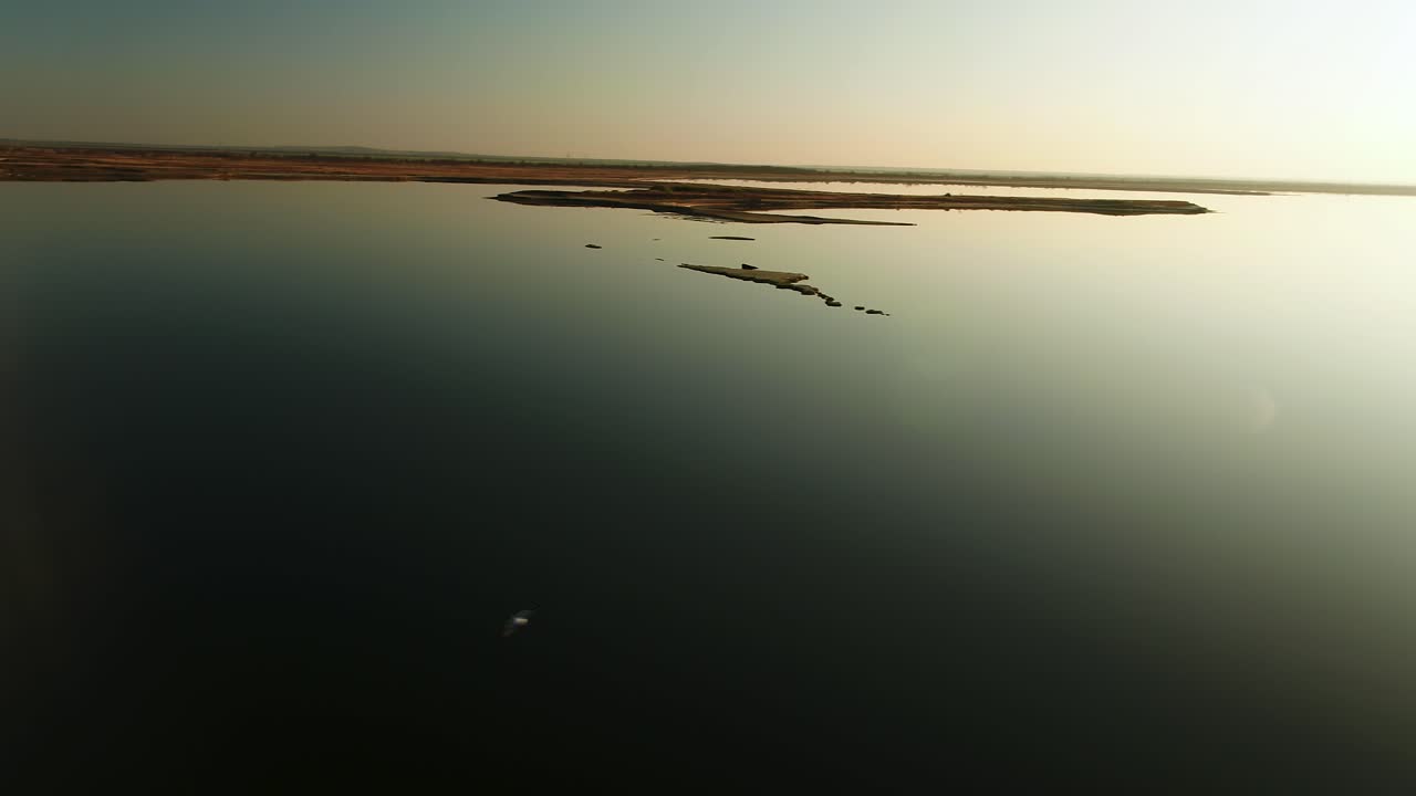 해가 뜨거나 해가 지면 물 위 를 날아다니는 새 들 이 있는 호수 의 공중 풍경