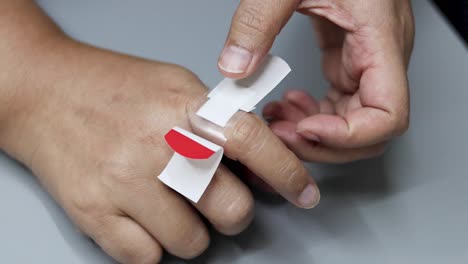 step-by-step demonstration of bandaging a finger