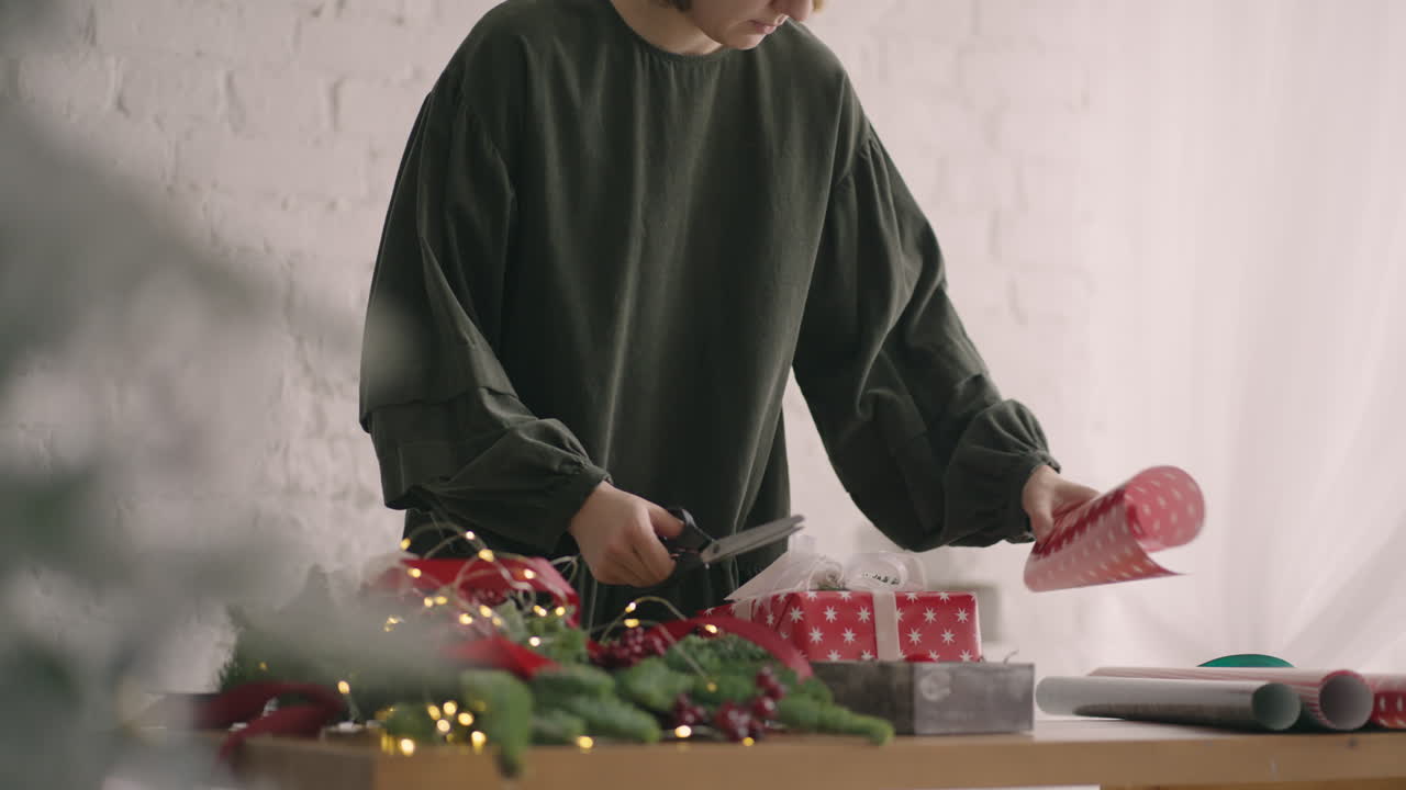 끈으로 포장된 상자를 장식하는 손을 자르세요. 여성 포장 판지 선물 상자 크리스마스 축하를 위해 준비된 다양한 장식 품목. 밧줄을 묶는 세부 여성 손