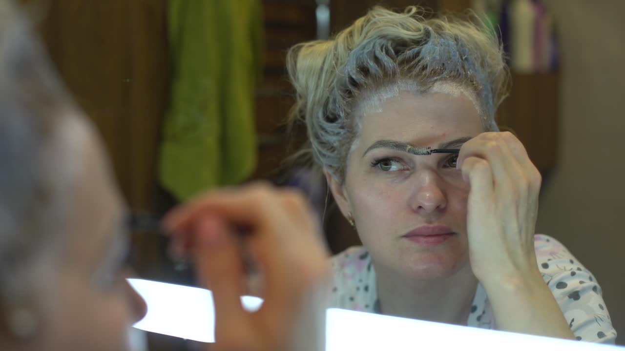 woman dyes her hair and eyebrows herself