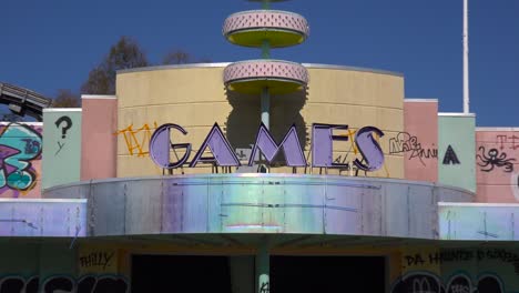 zoom out from an abandoned and graffiti covered game center at an amusement park presents a spooky and haunted image