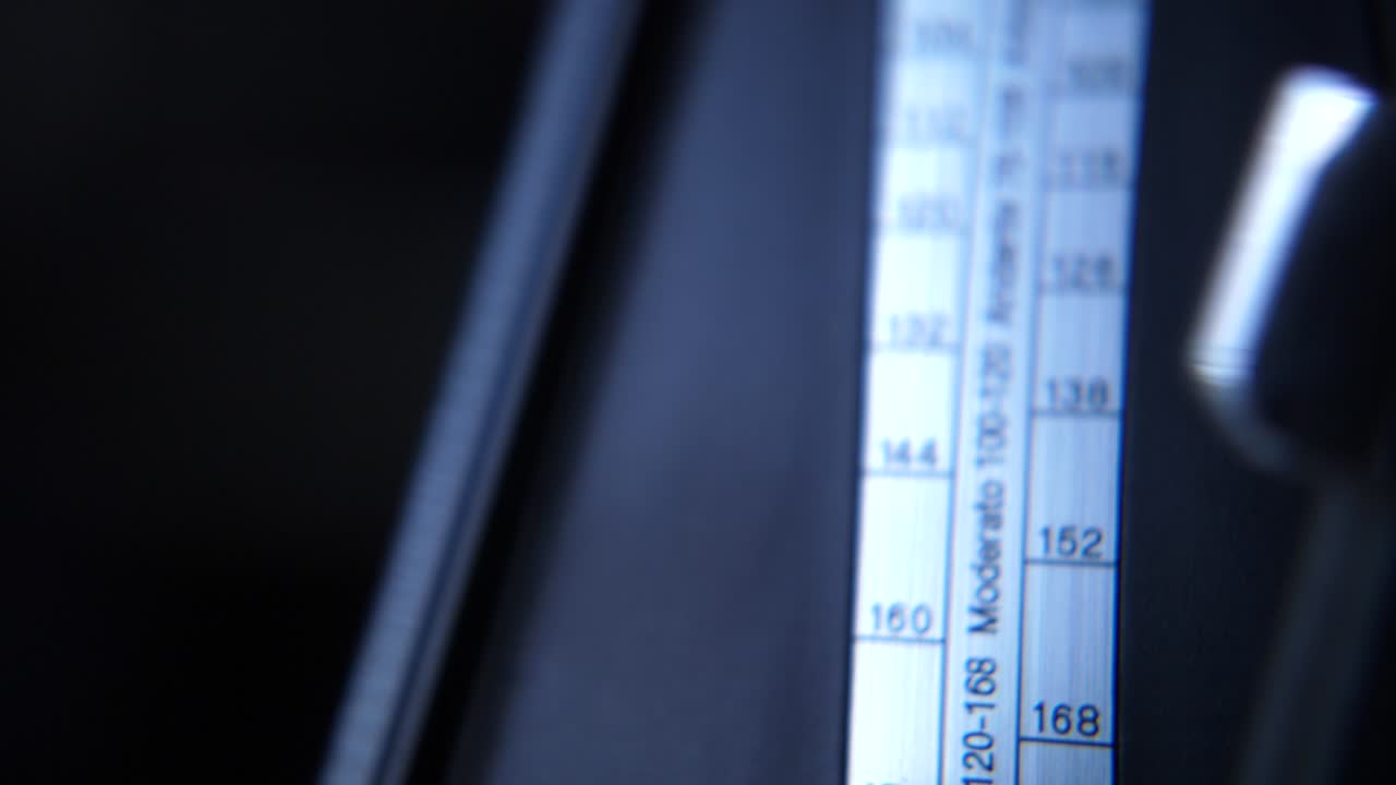 Close-up of a Metronome Pendulum Swinging Back and Forth