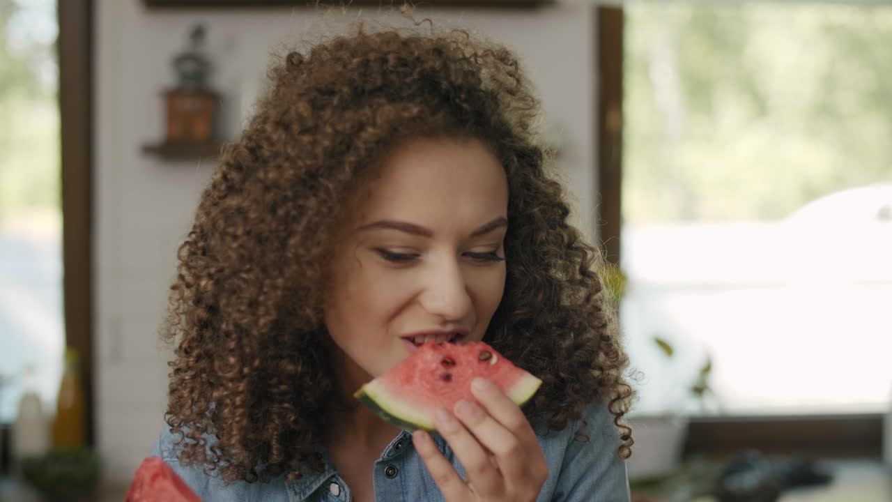 Beautiful woman eating a watermelon in the kitchen/Rzeszow/Poland