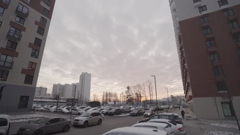 cityscape with apartment buildings, parking lot, and sunset