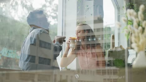 Happy-diverse-couple-spending-time-together-at-cafe,-drinking-coffee-and-talking