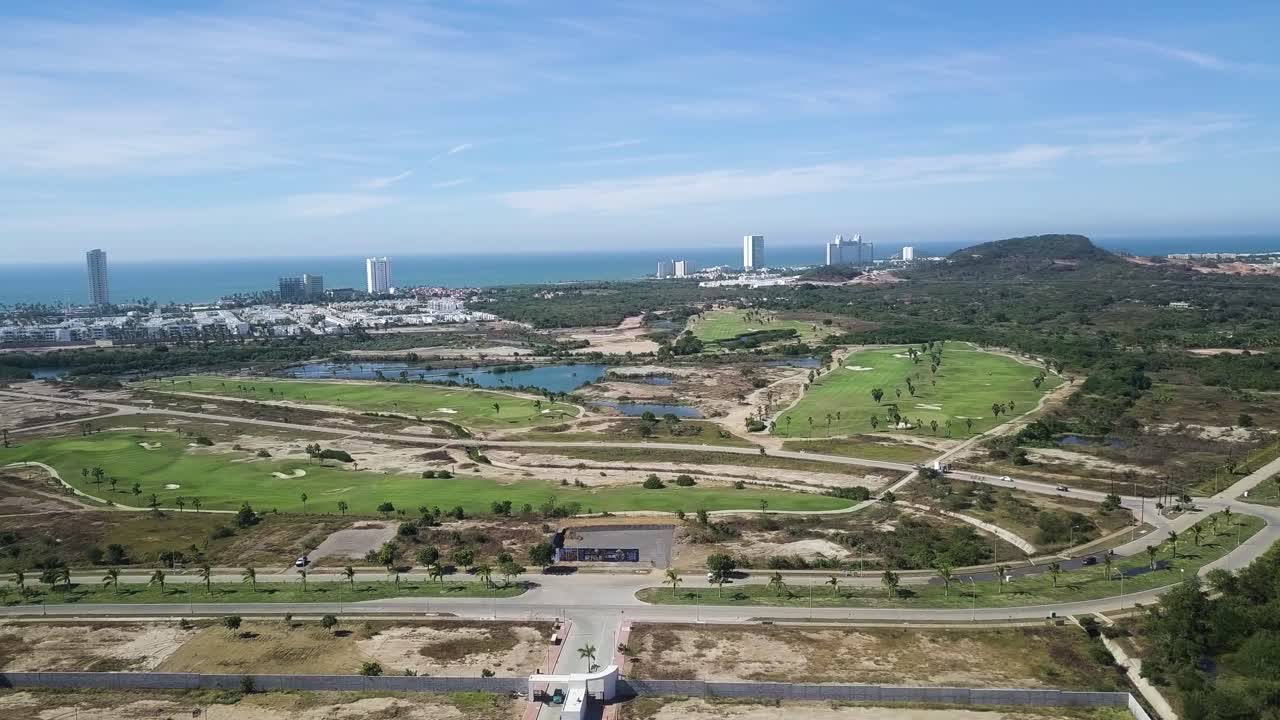 Aerial of green space park with buildings and ocean on horizon, Mazatlán, Mexico
