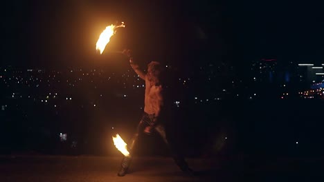 Young-blond-male-spins-two-burning-pois-Slow-motion