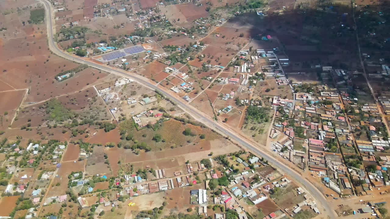 Ripresa dall'alto in basso di case, fattorie ed edifici ai margini di una città nel Kenya rurale