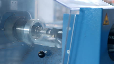 man drilling hole inside rubber hose on lathe machine. man working on lathe