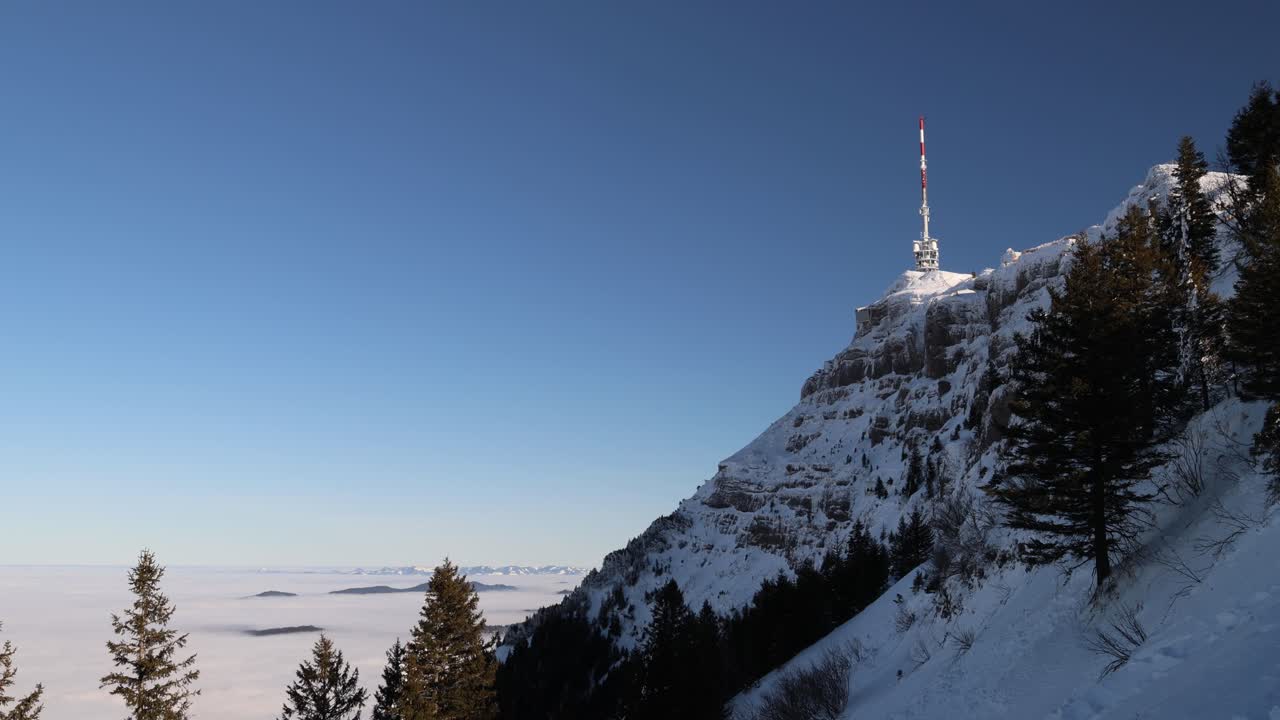 Radio broadcast tower on the mountain top, winter landscape establisher