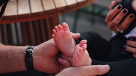 caucasian man clapping the tiny feet of a baby. close up. father plays with his adorable son.