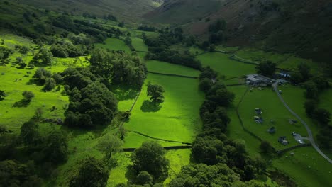 Exuberante-Y-Verde-Valle-Sombreado-En-Piscinas-Iluminadas-Por-El-Sol-Con-Una-Granja-Y-Revelando-Montañas-Más-Allá