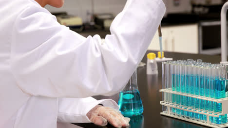 young scientist using pipette to put chemical in test tube