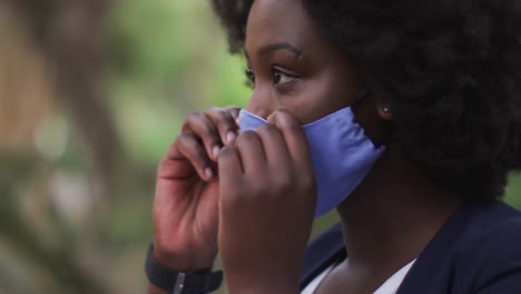 Mujer-Afroamericana-Poniéndose-Mascarilla-En-El-Parque