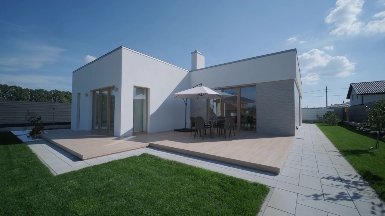 Casa bianca moderna con terrazza in legno e giardino